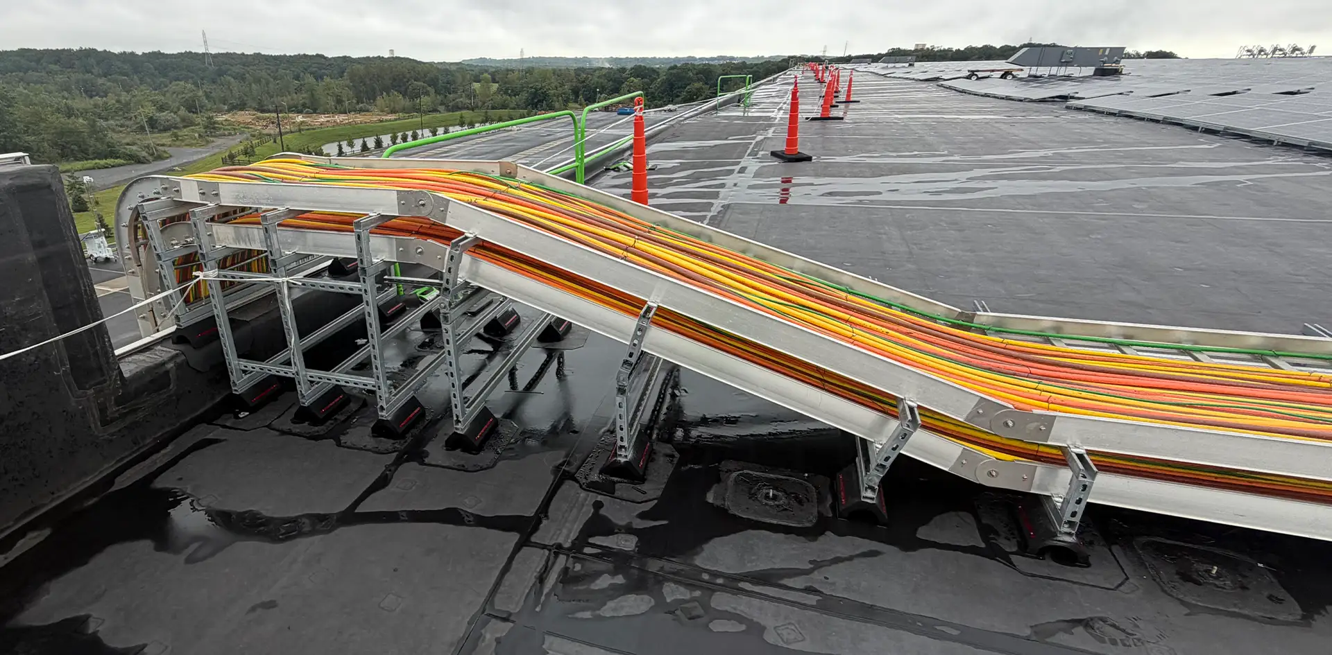 Heavy duty industrial wires running on a ramp on top of a commercial building.